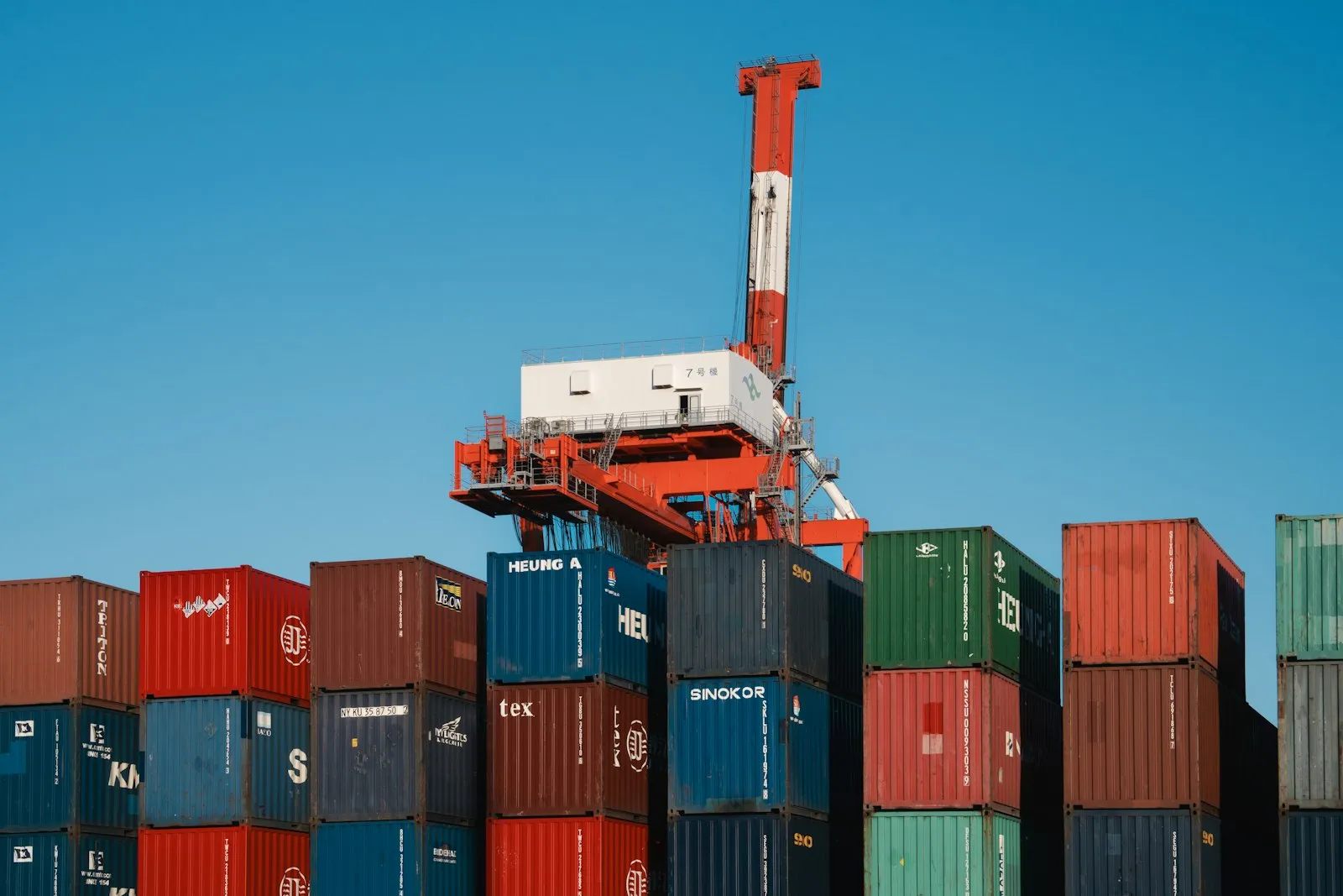 Gantry cranes over stacked shipping containers at a global port terminal